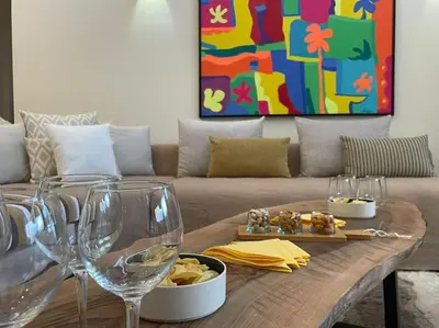 a living room with a couch and a table with wine glasses at Villa avec piscine chauffée en option Palmeraie in Marrakech