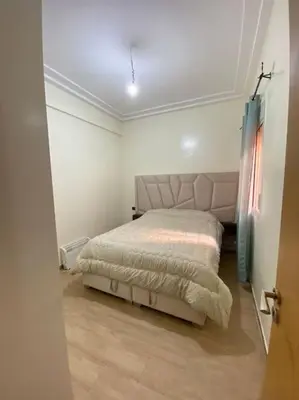 a bedroom with a bed in a white room at Appartement Moderne bien équipée reservation Juste pour les familles est les couples mariés in Marrakech