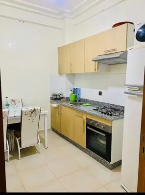 a kitchen with a table and a stove top oven at Appartement Moderne bien équipée reservation Juste pour les familles est les couples mariés in Marrakech