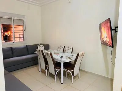a dining room with a table and chairs and a couch at Appartement Moderne bien équipée reservation Juste pour les familles est les couples mariés in Marrakech