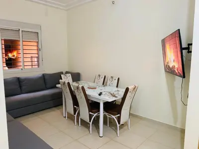 a dining room with a table and chairs and a couch at Appartement Moderne bien équipée reservation Juste pour les familles est les couples mariés in Marrakech