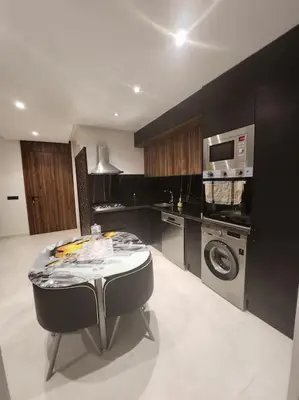 a kitchen with a table and a washing machine at Élégance urbaine, Gueliz central in Marrakech