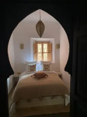 a bedroom with a large bed with a window at Riad Dar Fannan en exclusivité in Marrakech