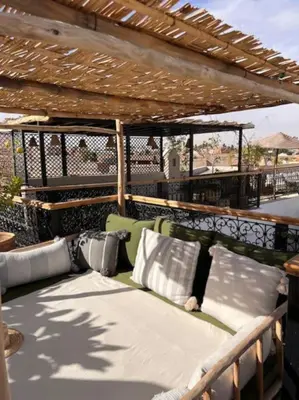 a couch sitting under a pergola on a balcony at Riad Dar Fannan en exclusivité in Marrakech