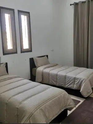 two beds in a room with two windows at Villa S in Marrakech