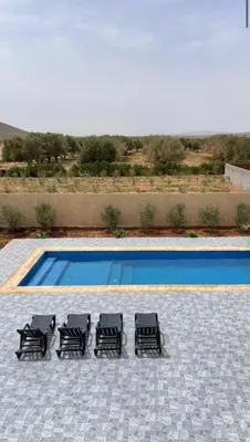 a group of four black chairs next to a pool at Villa S in Marrakech