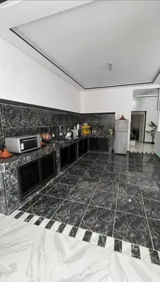 a large kitchen with a black and white tile floor at Villa S in Marrakech