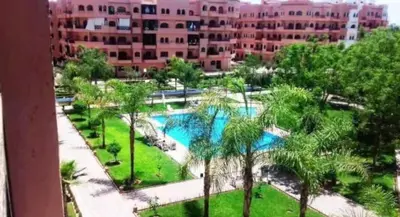 an aerial view of a park with palm trees and buildings at appartement Nizar in Marrakech