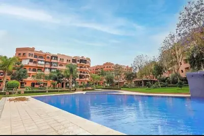 a large swimming pool in front of some buildings at appartement Nizar in Marrakech