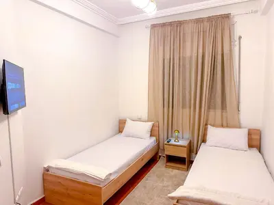 two beds in a small room with a tv at Luxoria Home - Pool & 3 min To Gueliz in Marrakech