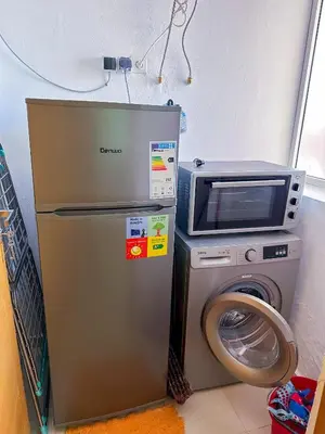 a refrigerator and a microwave next to a washing machine at Luxoria Home - Pool & 3 min To Gueliz in Marrakech
