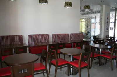 a dining room with tables and red chairs at Hotel Relax Marrakech in Marrakech