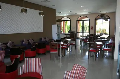 a dining room with tables and chairs and windows at Hotel Relax Marrakech in Marrakech