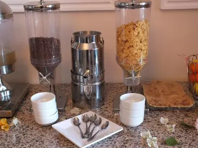 a counter topped with containers of cereal and spoons at Hotel Relax Marrakech in Marrakech
