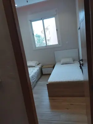 a small room with two beds and a window at Appartement au centre Marrakech in Marrakech