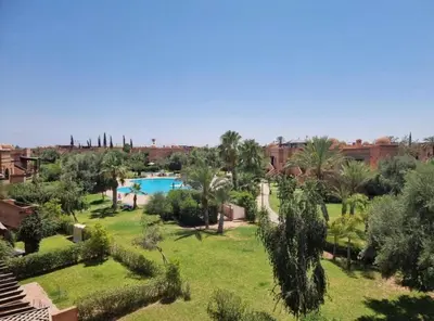 a garden with a swimming pool and palm trees at Dar Celya Sfia in Marrakech