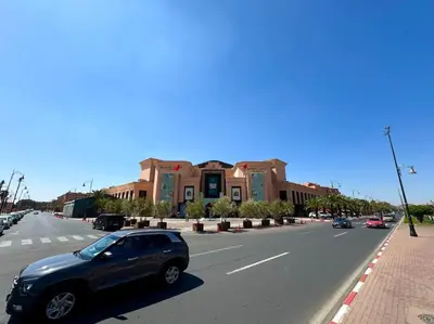 a black car driving down a street with buildings at Piscine Hivernage plein Centre in Marrakech