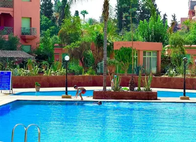 a person is playing in a swimming pool at Piscine Hivernage plein Centre in Marrakech