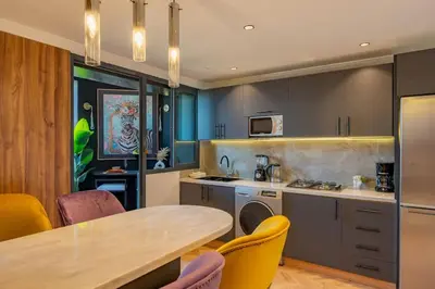 a kitchen with a table and some yellow chairs at Piscine Hivernage plein Centre in Marrakech