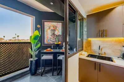 a kitchen with a table with chairs and a painting at Piscine Hivernage plein Centre in Marrakech