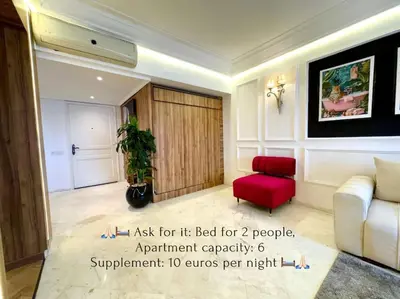 a living room with a couch and a red chair at Piscine Hivernage plein Centre in Marrakech