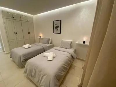 two beds in a white room with towels on them at Centre ville Marrakech Guéliz in Marrakech