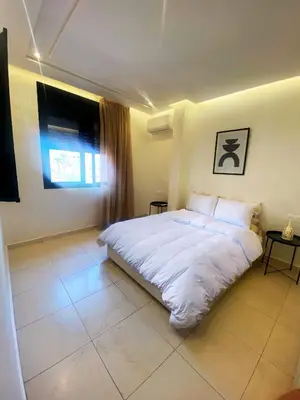 a bedroom with a white bed and a window at Centre ville Marrakech Guéliz in Marrakech