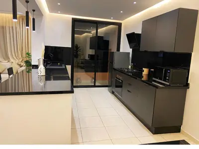 a kitchen with black cabinets and a counter top at Centre ville Marrakech Guéliz in Marrakech
