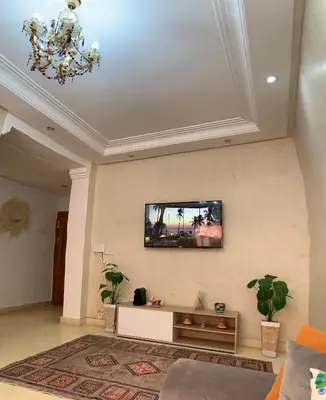 a living room with a tv on the wall at Tulipe Family House-Pool and Parking in Marrakech