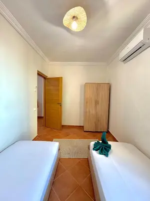 a bedroom with two beds and a wooden door at Gueliz Marrakech in Marrakech