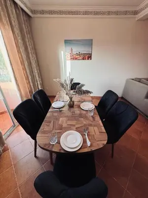a dining room table with chairs and plates on it at Gueliz Marrakech in Marrakech