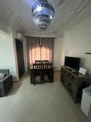 a living room with a table and chairs and a chandelier at Appartement Lana Guéliz Marrakech in Marrakech