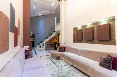 a living room with a long couch and a staircase at Duplex with private pool in Marrakech
