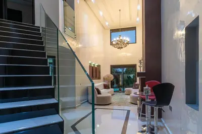 a living room with stairs and a chandelier at Duplex with private pool in Marrakech