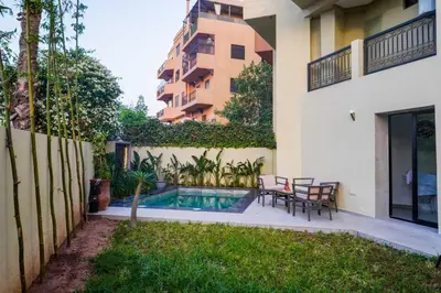 a backyard with a pool and a table and chairs at Duplex with private pool in Marrakech