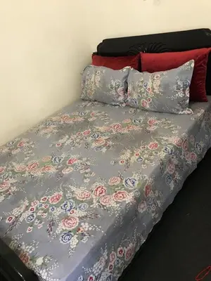 a bed with a gray comforter with flowers on it at Dari in Marrakech