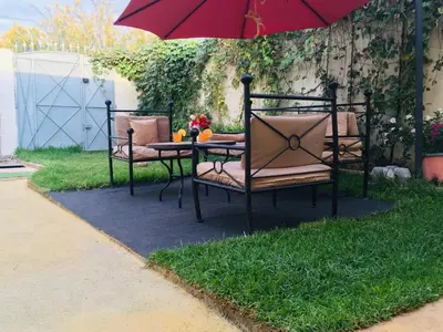 a table and chairs under an umbrella on a lawn at Dari in Marrakech