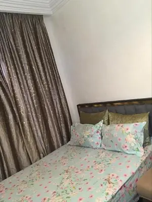a bedroom with a bed with floral sheets and pillows at Dari in Marrakech