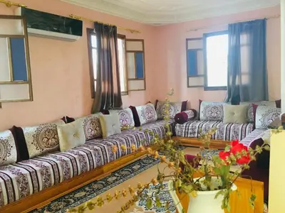 a living room with a long couch and windows at Dari in Marrakech