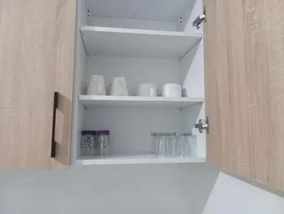 a cupboard with mugs and glasses in it at superbe appartement à côté de la gare à Gueliz Marrakech in Marrakech