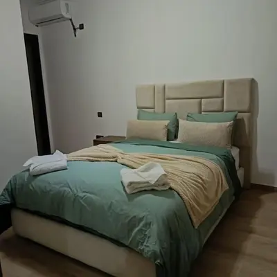 a bedroom with a large bed with green sheets and pillows at superbe appartement à côté de la gare à Gueliz Marrakech in Marrakech