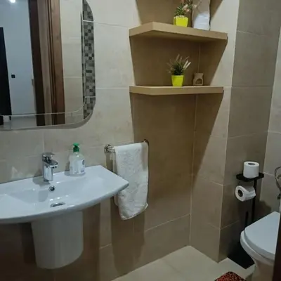 a bathroom with a sink and a mirror and a toilet at superbe appartement à côté de la gare à Gueliz Marrakech in Marrakech