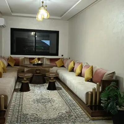 a living room with a couch and a tv at superbe appartement à côté de la gare à Gueliz Marrakech in Marrakech