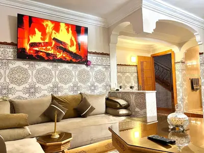 a living room with a couch and a fireplace at Cozy Apartment near airport in Marrakech
