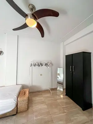 a bedroom with a ceiling fan and a black cabinet at Élégant appart 3 chambres cozy avec piscine in Marrakech