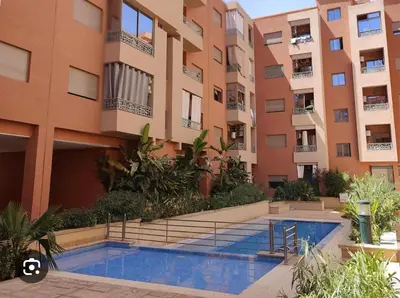 a swimming pool in front of a building at Élégant appart 3 chambres cozy avec piscine in Marrakech