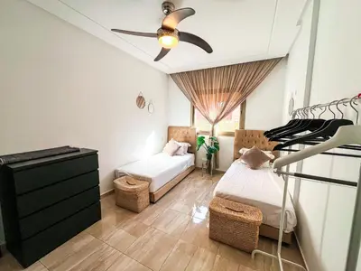 a bedroom with two beds and a ceiling fan at Élégant appart 3 chambres cozy avec piscine in Marrakech