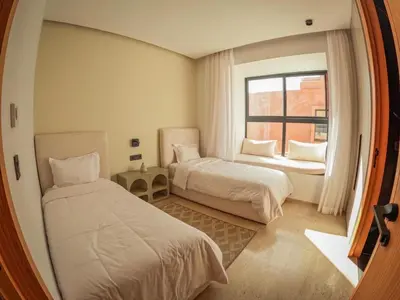 a hotel room with two beds and a window at Villa iris in Marrakech