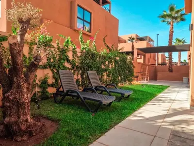 two chairs sitting in the grass next to a building at Villa iris in Marrakech
