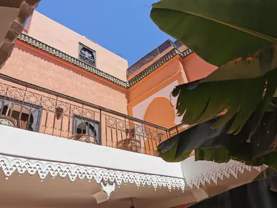 a balcony of a house with a large plant at Riad les ANGES DU DESERT in Marrakech